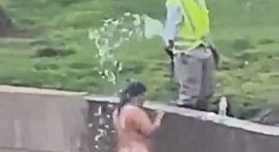 Gardener helps naked woman wash herself right on the street (3 photos)