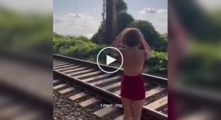 A girl's unsuccessful attempt to take a photo against the background of an approaching train