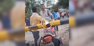 В Индии полицейский дал пощечину мотоциклисту, пытавшемуся проехать через закрытый переезд